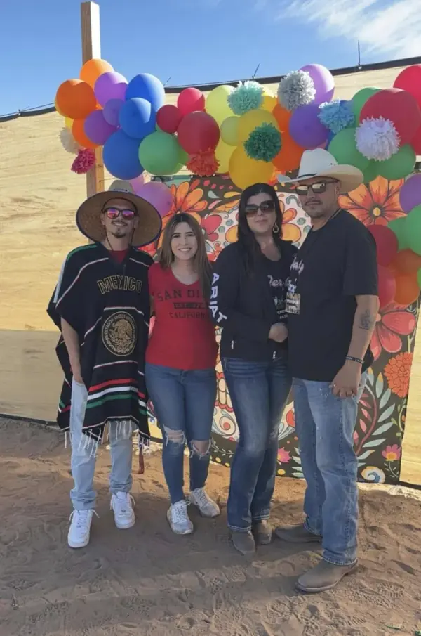The Fixx Family dressed up in front of a flower wall at a fair