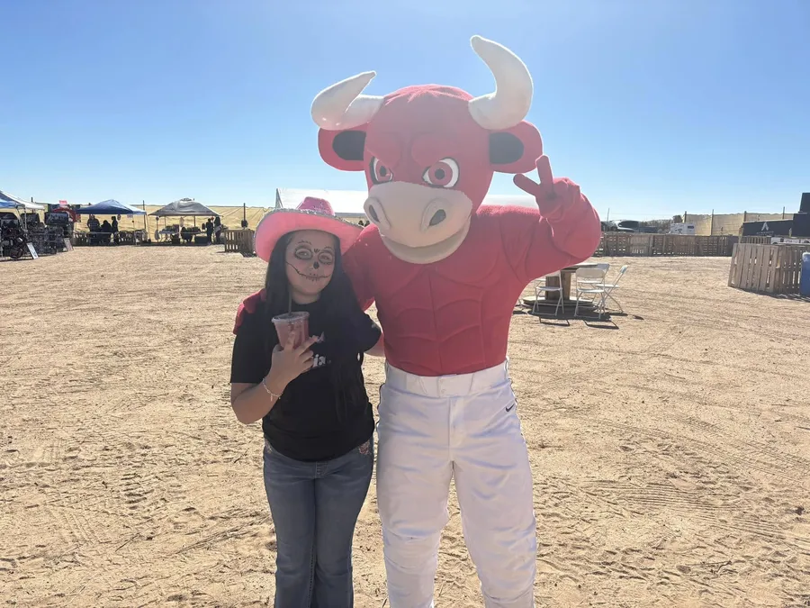 A Jerky Fixx family member with a bull mascot at a fair