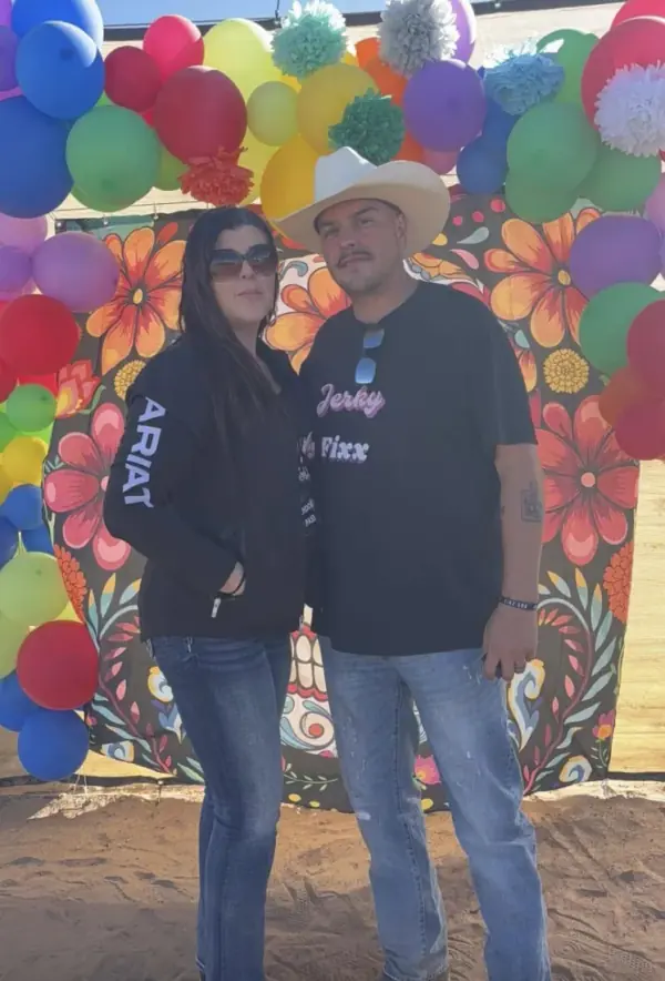 Jerky Fixx couple in front of a flower balloon wall