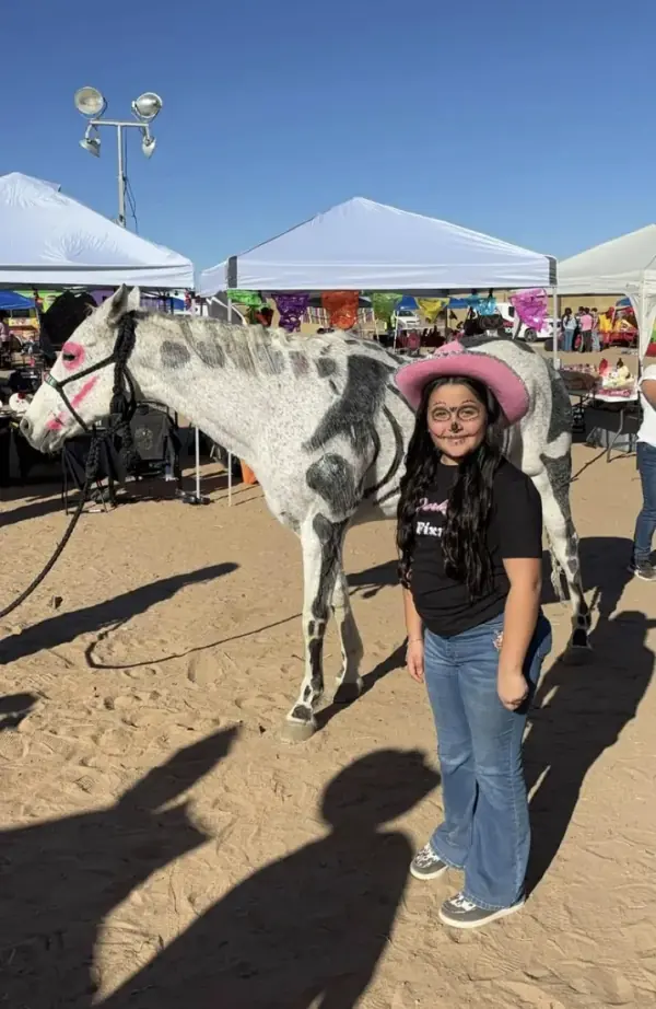 A young Fixx Family member next to a painted horse at the fair